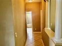Hallway with tile flooring leading to a bathroom with a tub, complemented by decorative columns at 1838 Palmerston Cir, Ocoee, FL 34761