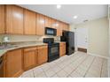 Bright kitchen featuring wood cabinetry, granite countertops, and black appliances at 205 Hill St # 205, Casselberry, FL 32707