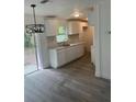 Bright kitchen featuring new laminate flooring, white cabinets, and a sliding glass door at 211 Cadillac Ct, Altamonte Springs, FL 32701