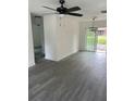 A spacious living room featuring sleek gray laminate flooring and a modern ceiling fan at 211 Cadillac Ct, Altamonte Springs, FL 32701