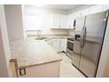 Kitchen boasts white cabinets, stainless steel appliances, granite countertops, and tile flooring at 2936 Antique Oaks Cir # 71, Winter Park, FL 32792