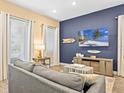 Inviting living room with blue accent wall, stylish decor, and ample natural light at 3095 Key Lime Loop, Kissimmee, FL 34747