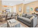Cozy living room with gray sofa, wood floors, and an open floorplan to kitchen and dining at 3095 Key Lime Loop, Kissimmee, FL 34747