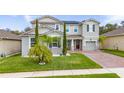 Charming two-story home with a well-manicured lawn and inviting brick-paved driveway at 3252 Jackson Bluff Way, Clermont, FL 34711
