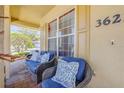 Cozy front porch featuring wicker seating with blue cushions and brick flooring at 3621 Casello Dr, New Smyrna Beach, FL 32168