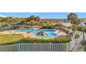 Community pool area surrounded by palm trees and manicured landscaping with a lake view at 3635 Kingswood Ct, Clermont, FL 34711