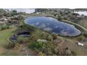 Drone shot shows the home's location near a pond and lake, surrounded by lush greenery, and clear blue skies at 40610 Babb Rd, Umatilla, FL 32784