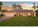 Inviting single-story home with a lush front lawn, brick facade, and an attached garage on a large grassy lot at 425 N Pine Meadow Dr, Debary, FL 32713