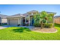Charming one-story home featuring a well-manicured lawn, a two-car garage, and a blue front door at 4862 Grand Vista Ln, St Cloud, FL 34771