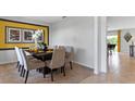Spacious dining room with plush chairs, dark table, and a yellow-themed accent wall at 5215 Ligonberry St, Lakeland, FL 33811