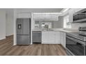 Modern kitchen featuring stainless steel appliances, white cabinetry, and wood-look flooring at 5669 Parkview Lake Dr, Orlando, FL 32821