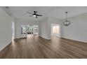 Open living room with wood-look flooring, a ceiling fan, and doors leading to a screened lanai at 5669 Parkview Lake Dr, Orlando, FL 32821