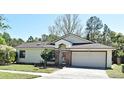 Charming one-story home boasts a well-manicured lawn, brick accents, and an attached two-car garage at 691 Monroe Harbor Pl, Sanford, FL 32773