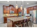 Spacious kitchen island with granite countertops, stainless steel appliances, and stylish pendant lighting at 8356 Corkfield Ave, Orlando, FL 32832