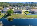 Home with screened-in pool overlooking tranquil waterfront and mature landscaping in the backyard at 8706 Irmastone Way, Orlando, FL 32817