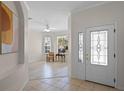 Bright foyer with decorative glass door and view of a living room with wood floors and plenty of natural light at 9774 Nonacrest Dr, Orlando, FL 32832