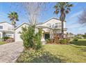 Beautiful two-story home with manicured lawn, lush landscaping, and a welcoming green front door at 1207 Winding Cypress Ct, Kissimmee, FL 34746