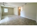 The living room boasts tile flooring, light walls, and a view to the staircase at 10079 Memoir Ave, Winter Garden, FL 34787