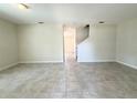 Spacious open-concept living room with neutral walls and tile flooring leading to the stairwell at 10079 Memoir Ave, Winter Garden, FL 34787
