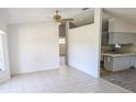 Open-concept living room featuring neutral tile flooring that leads to the kitchen area, bright and airy at 11847 Ocklawaha Dr, Leesburg, FL 34788