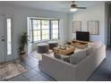 Bright living room featuring a bay window, neutral color palette, and stylish furnishings at 11847 Ocklawaha Dr, Leesburg, FL 34788