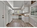Well-lit kitchen featuring white cabinetry, modern appliances, and wood-look flooring at 119 Winterglen Dr Dr, Sanford, FL 32771