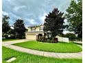 Beautifully landscaped home with a lush green lawn, mature trees, and a charming facade at 1379 Crane Crest Way, Orlando, FL 32825