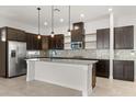 Modern kitchen features stainless steel appliances, dark cabinetry, and a granite-topped island with pendant lighting at 14165 Moniz Ave, Orlando, FL 32827