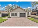 Modern house features brick driveway, window, and a one-car garage with a gray door at 1517 E Esther St, Orlando, FL 32806