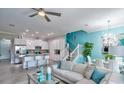 Open concept living room with stylish furnishings, modern lighting, and seamless flow to kitchen at 159 Captiva Dr, Davenport, FL 33896