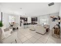 Open concept living and dining area with tile floors, stainless steel appliances, and modern design at 2706 Rowan St, Tavares, FL 32778