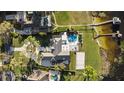 Aerial view of estate showing pool, beach volleyball court, personal dock, and lush landscaping at 2844 Marquesas Ct, Windermere, FL 34786