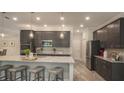 Modern kitchen featuring stainless steel appliances, a granite countertop island, and stylish cabinetry at 355 S Sunset Ave, Mascotte, FL 34753