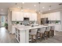 Spacious kitchen featuring stainless steel appliances, a large island, and modern lighting at 355 S Sunset Ave, Mascotte, FL 34753