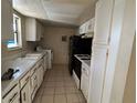 Long galley kitchen with white cabinets and black appliances at 4358 Aqua Vista Dr # G, Orlando, FL 32839