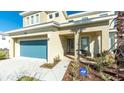 Inviting front of home, featuring a blue garage door, modern landscaping and manicured beds at 4507 Monado Dr, Kissimmee, FL 34746