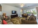 Comfortable living room with neutral toned walls, TV, couches, and sliding glass doors to the backyard at 4507 Monado Dr, Kissimmee, FL 34746