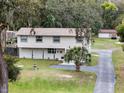 Two-story home with neutral siding, complemented by a landscaped front yard and a long driveway to a detached garage at 500 Forest Lake Dr, Altamonte Springs, FL 32714