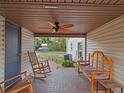 Relaxing covered brick patio furnished with rocking chairs and a bench at 500 Forest Lake Dr, Altamonte Springs, FL 32714