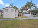 Rear exterior featuring a sprawling yard, mature trees, and attached garage and workshop at 500 Forest Lake Dr, Altamonte Springs, FL 32714