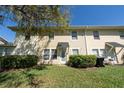 Townhome backyard featuring a grassy lawn and trimmed hedges at 5412 Caramella Dr, Orlando, FL 32829
