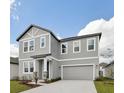 Well-designed two-story home showcasing a gray color scheme, attached garage, and a neatly kept lawn at 5719 Cattle Ranch Dr, St Cloud, FL 34771