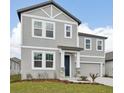 Attractive two-story home with a gray exterior, inviting entrance, and a well-maintained front lawn at 5719 Cattle Ranch Dr, St Cloud, FL 34771