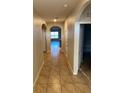Inviting hallway featuring neutral walls, tile flooring and arched doorways that lead to the living areas at 717 Squires Grove Dr, Winter Haven, FL 33880