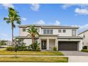 Beautiful two-story home with lush landscaping, modern design, and a well-manicured front lawn at 3881 Sonoma Blvd, Kissimmee, FL 34741