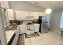 Functional kitchen featuring white cabinets, modern appliances, and easy-to-clean tile flooring at 1018 Martin Blvd, Orlando, FL 32825