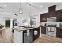 Open-concept kitchen with dark cabinets, a stainless steel dishwasher, a breakfast bar, and views to the dining area at 10257 Henbury St, Orlando, FL 32832