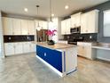 Modern kitchen featuring white cabinets, stainless steel appliances, and a contrasting blue island at 11810 Imaginary Way, Orlando, FL 32832