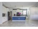 Spacious kitchen with stainless steel appliances, white cabinets and a gray backsplash with a blue island at 11810 Imaginary Way, Orlando, FL 32832