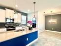Open-concept kitchen with island, stainless appliances, and adjacent dining and laundry areas at 11810 Imaginary Way, Orlando, FL 32832